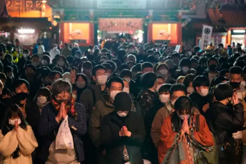 Getty Images Wearing masks, people in Tokyo visit the Shinto Kanda Myojin Shrine to mark the new year