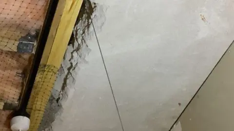 Qays Najm/BBC A damaged concrete ceiling panel - a side edge has crumbled away exposing a large gap.