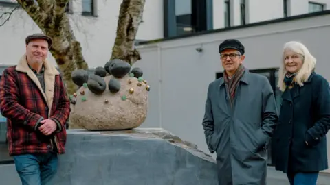 Arts University Plymouth Kurt Jackson with his sculpture in Plymouth, alongside Dr Stephen Felmingham and Lorraine Evans