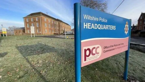BBC Wiltshire Police HQ sign in front of the brown brick police headquarters building
