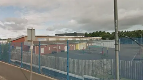 Google A school building with playground in front