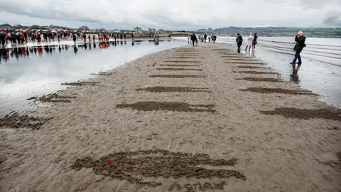 Peter Sandground Representations of soldiers on Ayr beach poignantly disappear under the water