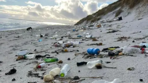 Blue skies over Sanday highlight the large quantities of plastic found on just one beach. Bottles add up to the same amount of driftwood and seaweed.