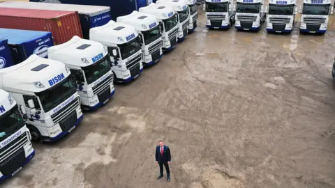 Andy Scott Andy Scott with the lorries of one of his haulage firms