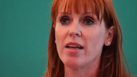 Close up of Rayner against a green background
