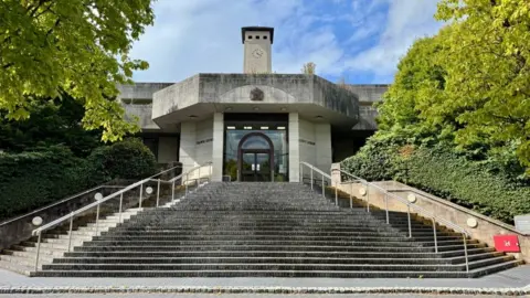 Look at some steps towards Newport Crown Court, which is an egg color and has a big clock tower
