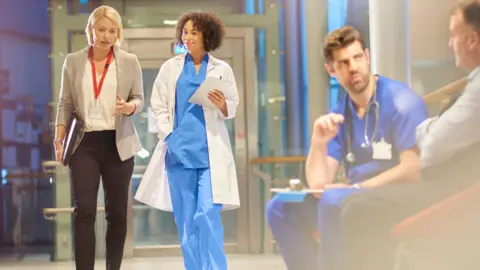 A hospital corridor with doctors talking.