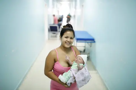 Nacho Doce/REUTERS Lismaris, 21, a Venezuelan from Monagas state, holds her three-day-old baby Cecilia at a maternity hospital in Boa Vista, Roraima state, Brazil, 21 August 2018