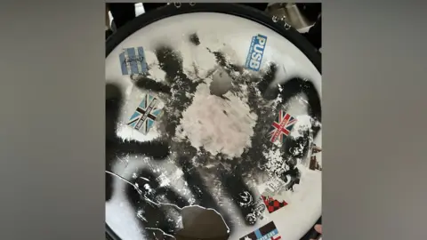 The torn drum skin has PUSB, Sky Blue Army and In Our Coventry Homes stickers on it.