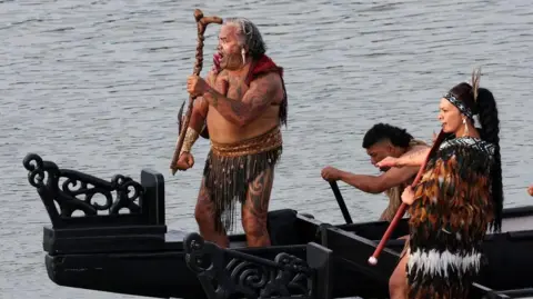 Getty Images A boat carries Māori warriors under the bridge at Waitangi after a service to commemorate the national day