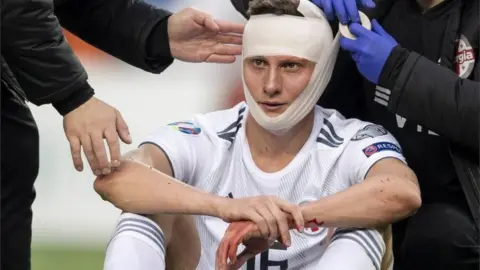 EPA Georgia's Jemal Tabidze is treated by doctors after colliding with Switzerland's Fabian Schaer at a Euro 2020 qualified, 23 March 2019