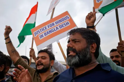 Reuters Hindu activists hold placards and Indian national flags, as they chant the slogan, "Stop atrocities on Hindus", and protest attacks on religious places of Hindus in Bangladesh, in Ahmedabad, India August 13, 2024. REUTERS/Amit Dave