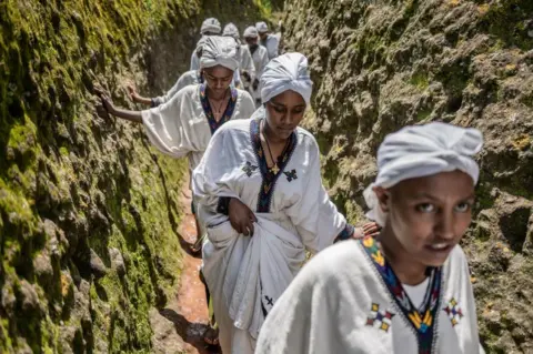 AFP Young women walk through the cave of Saint George during Ashenda festival, at Saint George Church, in Lalibela, Ethiopia.