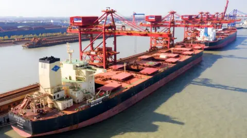 Getty Images Aerial photo taken on December 9, 2020 shows a ship unloader unloading iron ore imported from Australia at an iron ore operation terminal in Taicang Port in Suzhou, East China's Jiangsu Province, China