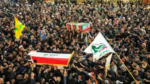 EPA People mourn next to the coffins of slain Abu Mahdi al-Muhandis and Qassem Soleimani during a funeral procession in Najaf, Iraq, 04 January 2020