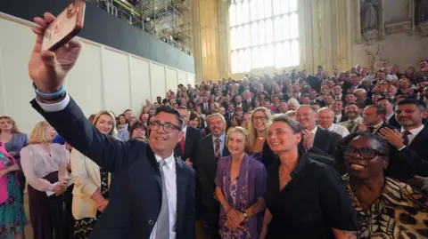 PA Media Andy Burham poses for a selfie with his parliamentary supporters, including Jarrow and Gateshead East MP Kate Osborne (second right)