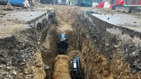 Julia Gregory/ BBC Roadworks including pipes under a road.