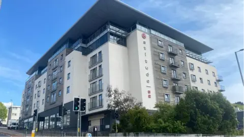 The outside of the multi-storey Latitude 52 building in Devonport, Plymouth, taken in 2021. The building has multiple windows and balconies. 