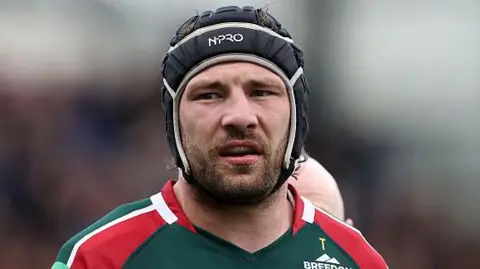 Harry Wells in a green and red Leicester Tigers jersey during a match