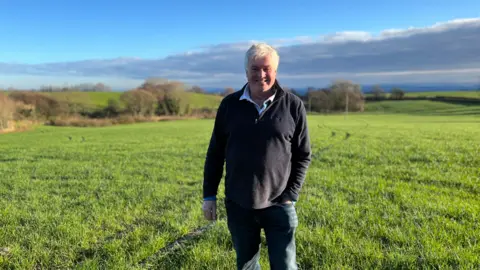 bbc farmer standing in a lovely green field