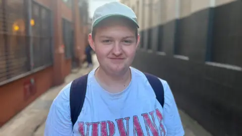 A man wearing a cap and a Nirvana top