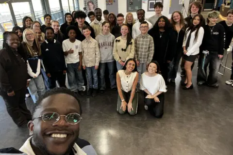 A selfie showing a large group of children posing for a picture in a youth centre.