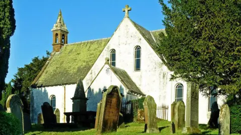 Mary and Angus Hogg A small white church with gravestones in front of it and trees beside it
