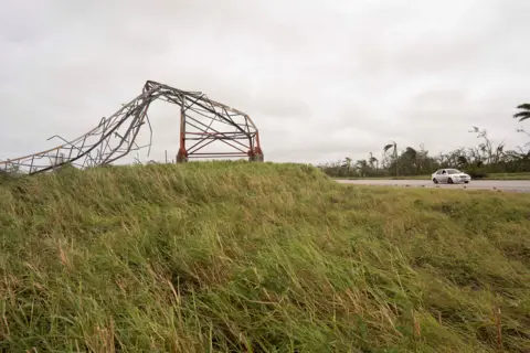 Reuters Car passes a toppled pylon on a motorway