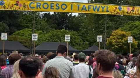 The backs of a large number of people queuing to gain entry to the Tafwyl festival in Cardiff on Saturday