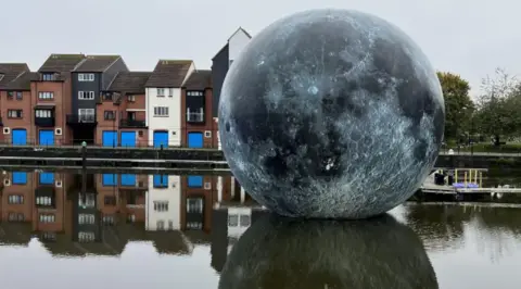 Image shows the Fallen Moon artwork in its full form on the surface of the water 