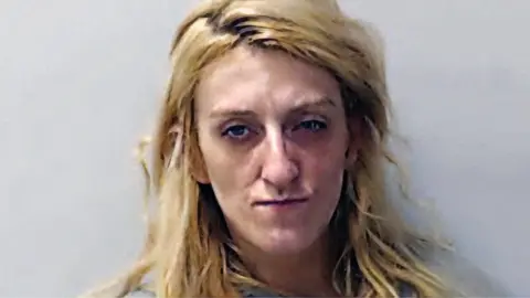Dionne Wilson, who has blonde hair and is wearing no make up, in a police mugshot
