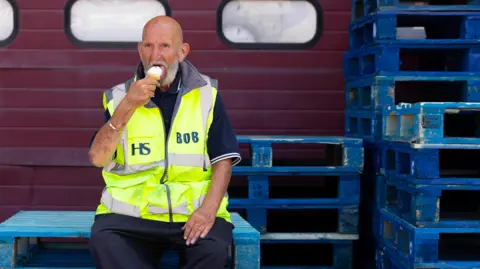 PA Media Bob enjoys a free ice cream handed out at TradePoint Barking in London as part of a B&Q TradePoint giveaway with more than 1,000 ice creams offered at selected stores across the UK, supporting trade workers during what is expected to be the hottest day of the year so far 