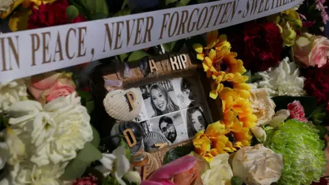 Getty Images Flower tributes and condolence messages are seen at the edge of Westfield Bondi Junction during a day of reflection on April 18, 2024