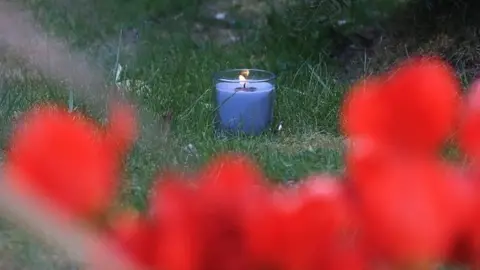 PA Media A lit candle marks one week since the death of PCSO Julia James, at her family home in Snowdown, near Aylesham