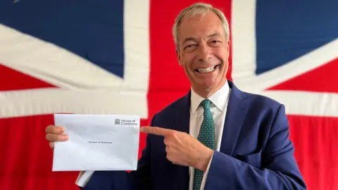 Stuart Woodward/BBC Nigel Farage holding an envelope welcoming him to the House of Commons