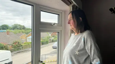 Diana Tasker looking out the living room window of her Scarborough home