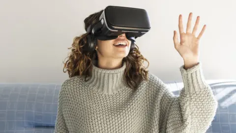 Getty Images A woman wearing VR goggles
