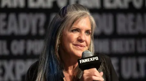 Thomas Cooper/Getty Images Close up shot of Jennifer Hale holding a microphone