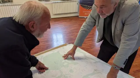 Energise Sussex Coast Two men discuss the project over a map of the site. 