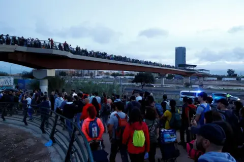 Reuters Columns of volunteers are seen marching to help with clean-up efforts after the floods in Valencia. 