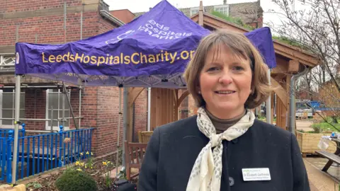 Cathy Minton/BBC Dr Elizabeth Garthwaite, a doctor wearing a navy coat and cream scarf with short brown hair 