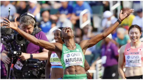 EPA Tobi Amusan with her hands raised to the air celebrating after setting a new world record in Oregon, the US - Sunday 24 July 2022