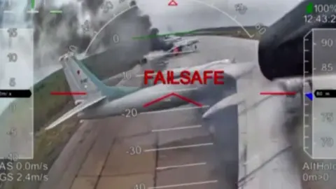 A screenshot from footage purportedly showing drone attack on Russian warplanes