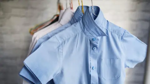 Getty Images A row of blue and white shirts hanging up
