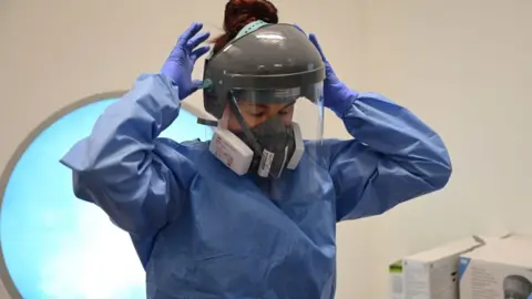 Getty Images NHS medic in PPE gown and gloves