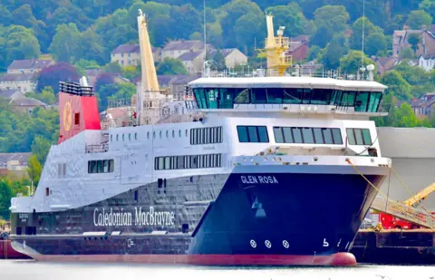 Christopher Brindle A large black and white ship with red funnels, moored at a quayside