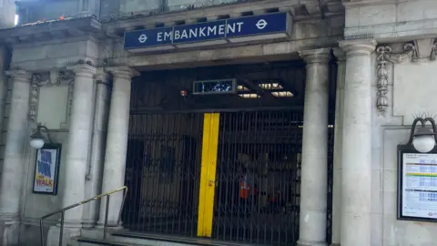 The entrance to Embankment station with gates pulled across it