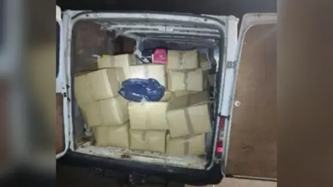 A police image of more than 10 brown boxes in the back of a white van