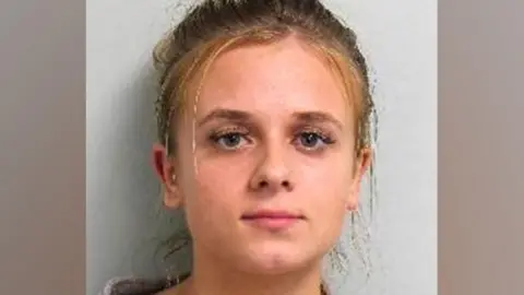 Custody image of Roksana Lecka. She is looking directly at the camera wearing a woollen type cardigan.