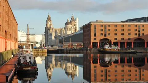 Shot of the royal albert docks, taken on a sunny day. The Liver building can be seen in the distance.